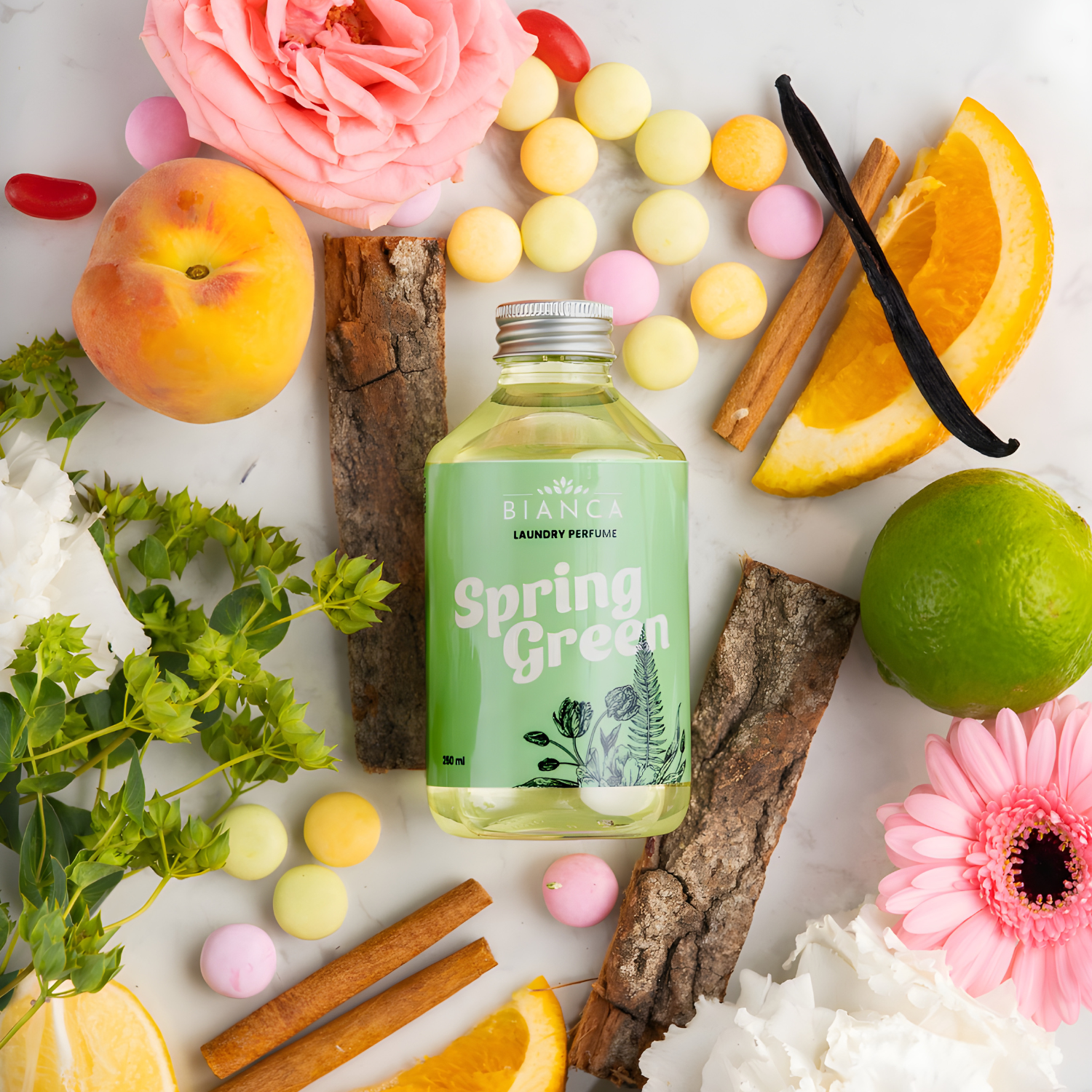 Spring Green laundry perfume bottle displayed with peach, lime, orange slices, florals, and green botanical elements.