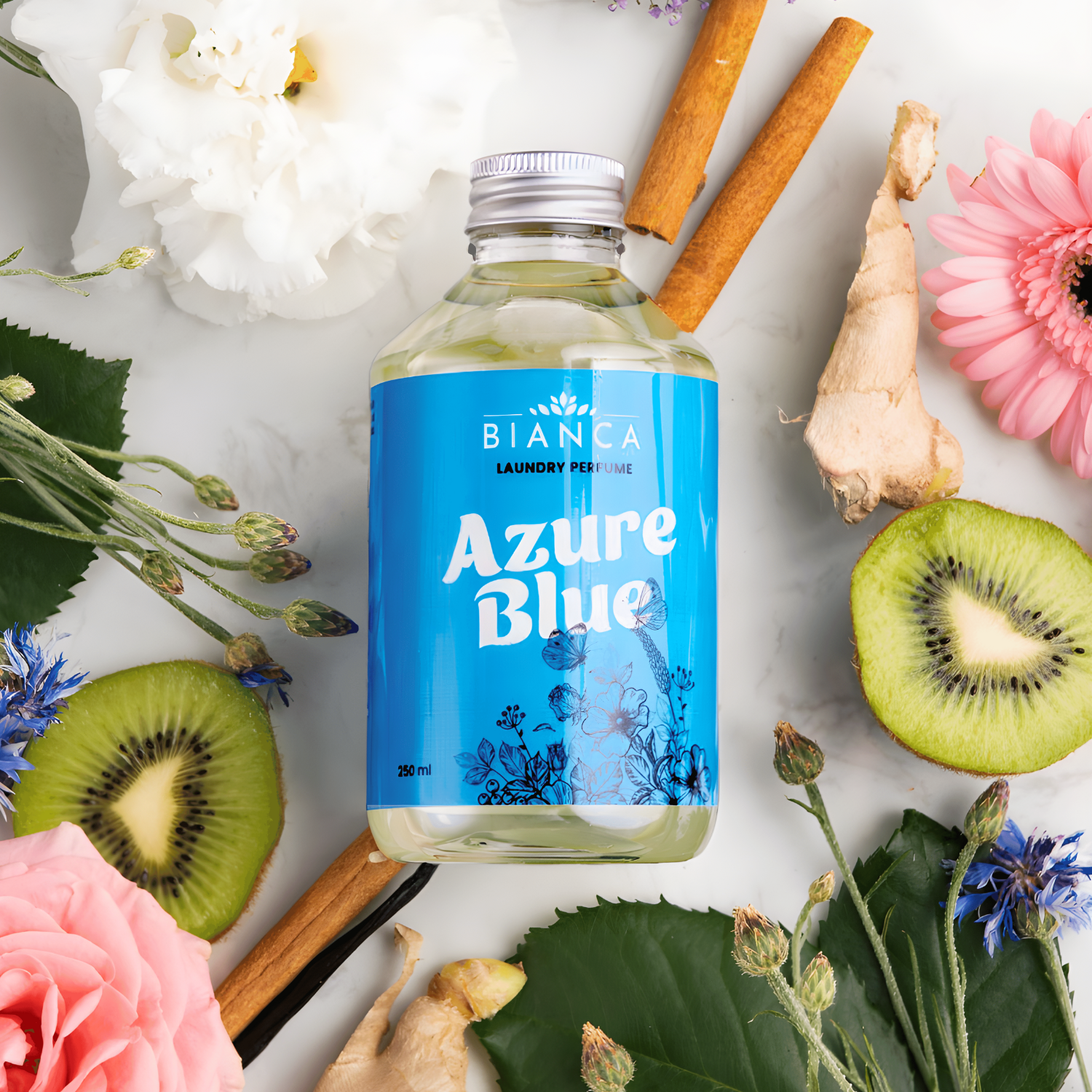 Azure Blue laundry perfume bottle surrounded by kiwi slices, ginger, cinnamon sticks, pink and white flowers, and blue botanicals, highlighting its fresh and aromatic fragrance notes.